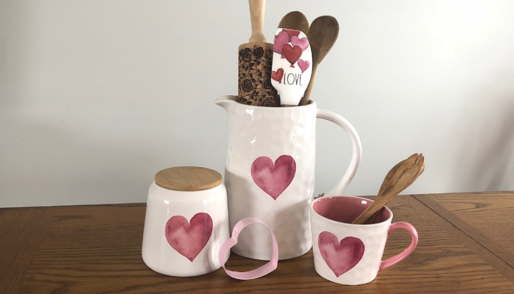 White and pink heart canister, jug and mug sitting on a wood table