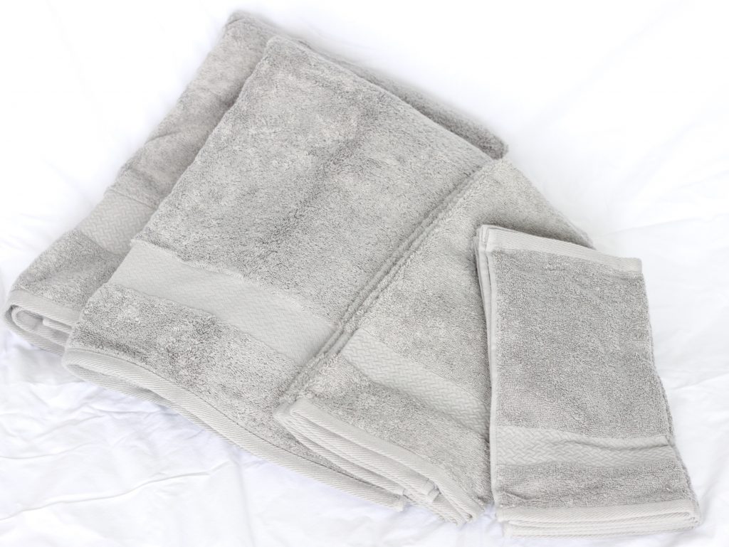 Set of grey towels on white background