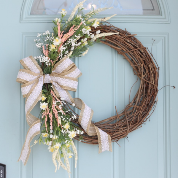 Close up of of a spring wreath hanging on a blue door
