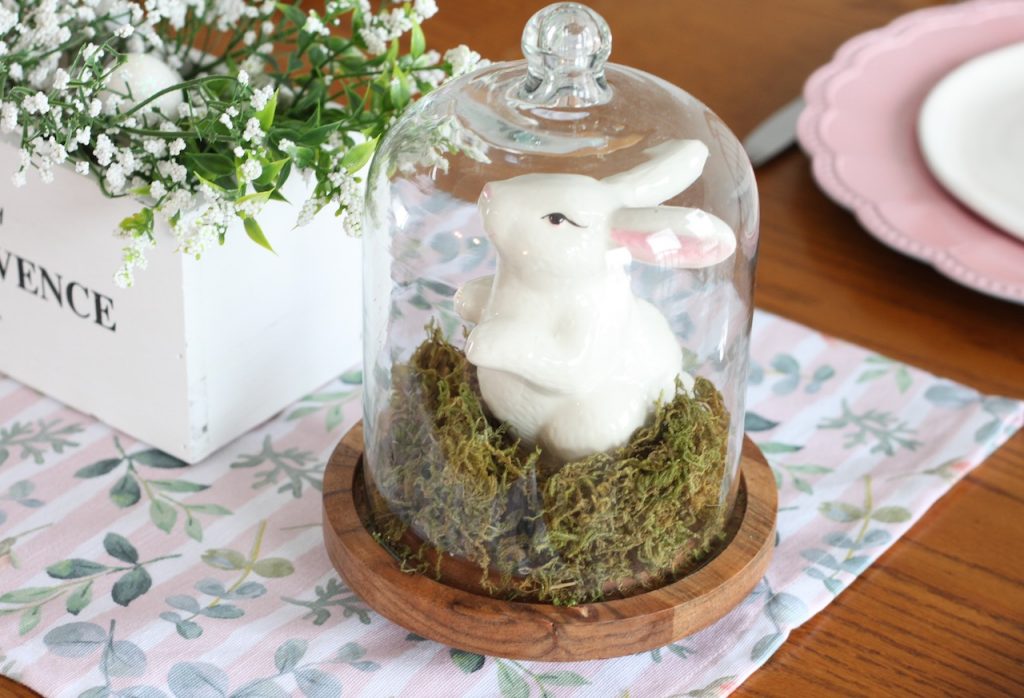 Glass cloche with green moss and bunny ornament inside
