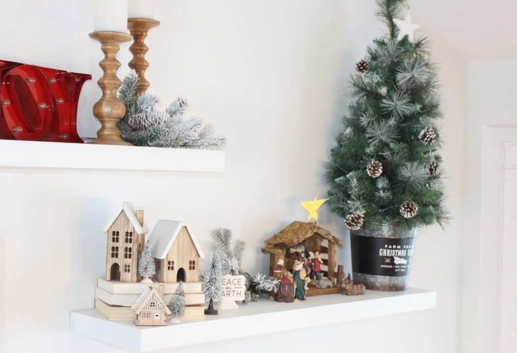 Christmas village, nativity and tree on a white shelf