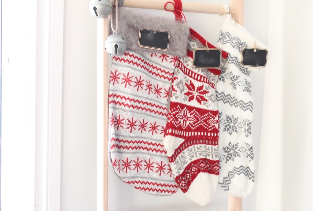 3 red and white stockings hanging on a ladder