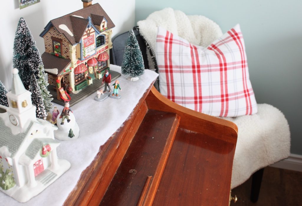 Village displayed on top of a piano for Christmas